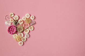 Heart made of buttons on a pink background. Valentine's Day card. Needlework.