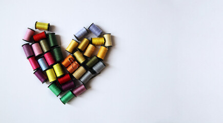 Heart made of multi-colored spools of thread. Concept of love for needlework Sewing, Tailor