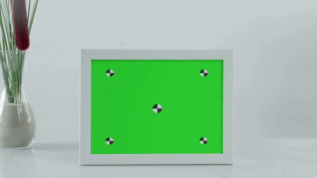 close up of photo frame with green screen with tracking markers