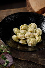 Appetizing traditional Russian dumplings, handmade. Still life on a wooden board. Close-up.