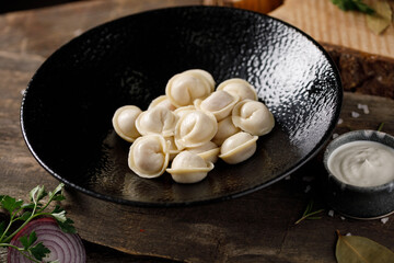 Appetizing traditional Russian dumplings, handmade. Still life on a wooden board. Close-up.