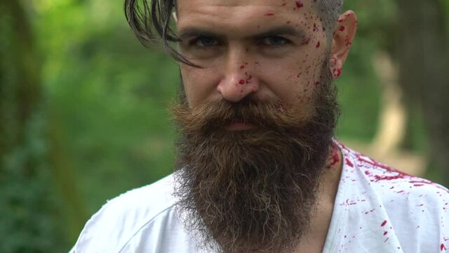 Killer or maniac man in spray of blood on Halloween. Crime horror, scary murder.