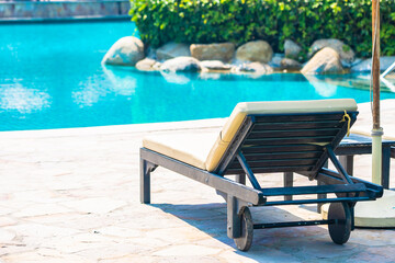 Outdoor swimming pool with sea ocean beach around umbrella and chair