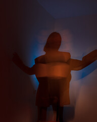 young woman in dark. yellow and blue lights. defocus