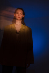 young woman in dark. yellow and blue lights. defocus