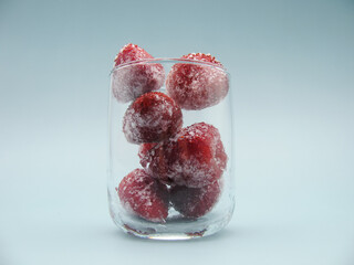 frozen red attractive strawberries in a clear glass. Side view.