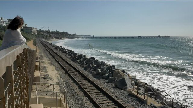 Senior mature woman watching the waves happy at the famous railroad track beautiful landscape pacific coast Orange county San Clemente