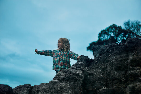 Preschooler standing on rock in the autumn