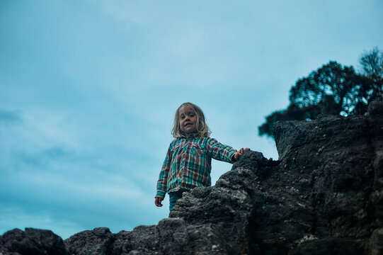 Preschooler standing on rock in the autumn