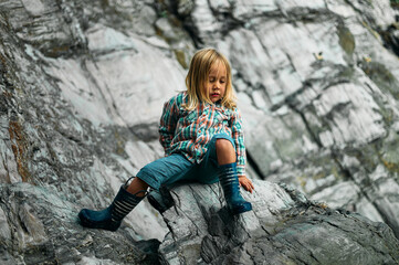 Naklejka na ściany i meble Preschooler climbing on rocks in the autumn