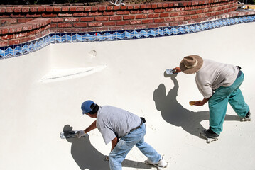 Masons smoothing swimming pool plaster