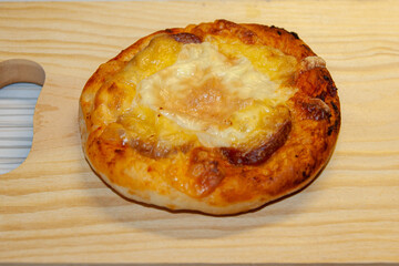 A small pizza with sausage and cheese.