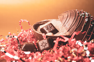 Open cocoa bomb on confetti and gold background