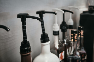 Obraz na płótnie Canvas Row of coffee flavoring syrup bottles with dispenser