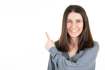 Young happy smiling woman over isolated white background pointing finger to the side