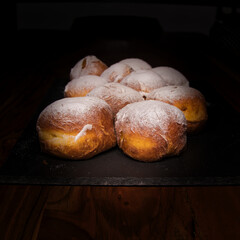 Berliner Krapfen, braun gebacken und mit Puderzucker bestreut