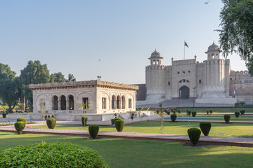 Morning view with garden and marble pavilion of white Alamgiri gate built by mughal emperor Aurangzeb as entrance to Lahore fort, a UNESCO World Heritage site, Punjab, Pakistan 