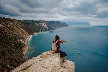 woman traveling with backpack tourist on seashore in summer