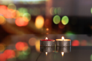 candles on glass table, moving blurred colorful city night in background.