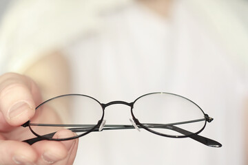 The concept of poor vision. Hold a contact lens and glasses in hand. A poster for advertising...