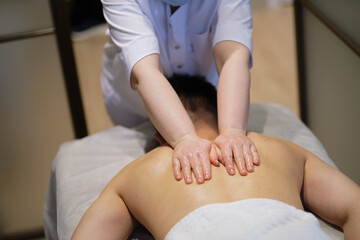 Fototapeta na wymiar Close-up of man enjoying in relaxing back massage . Man relaxing on massage table receiving massage