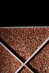 A set of grain cereals. Rice, buckwheat and millet groats in a wooden tray. A grocery set of cereals. Import of grain.