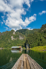 Obraz premium Landscape of lake with cleared blue sky, clouds, mountain and a floating house 