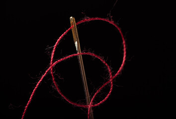needle and thread on a black background