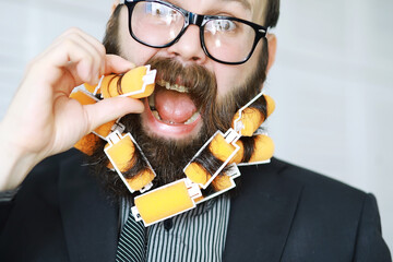 Cheerful hipster man with curlers in a beard. Surprised man with glasses looks in front.