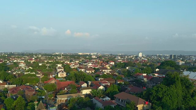 Cinematic aerial footage cityscape view of Yogyakarta city, Indonesia with blue sky background, taken from drone flying trucking right slowly