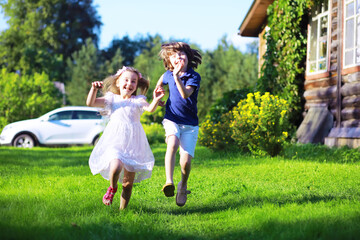 Fototapeta premium Young large family on a summer morning walk. Beautiful mother with children is playing in the park.