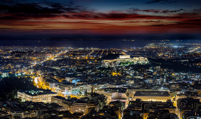 The illuminated cityscape of Athens, Greece, with the ancient Acropolis and busy streets around...