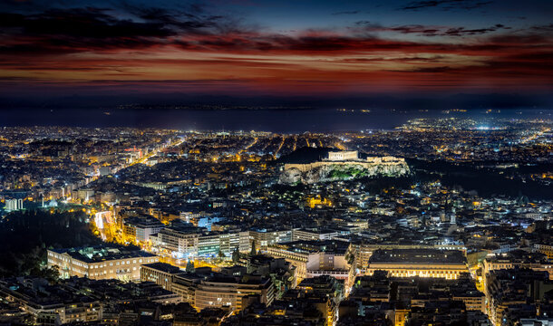 Fototapeta The illuminated cityscape of Athens, Greece, with the ancient Acropolis and busy streets around Syntagma square during night time