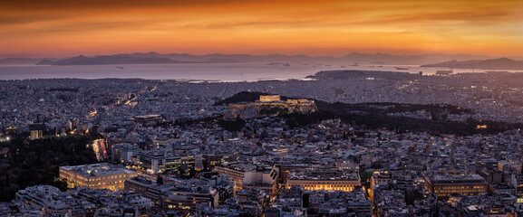 Panoramic view to the cityscape of Athens, Greece, with the illuminated Parthenon Temple of the Acropolis in the center and Syntagma Parliament during dusk