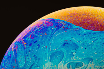 Fluid art made of colorful soap bubble film. Trendy Inkscape blurred background. Alien space planets art. Selective focus.