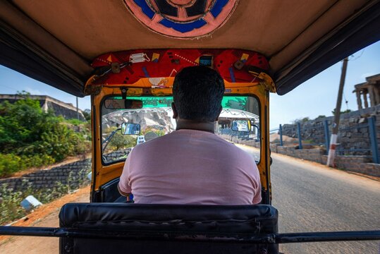 Hampi. India. Cab Driver Is Driving A Rickshaw Taxi With Passengers Through The Indian Village