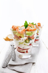 Salad with shrimp and avocado in two glasses on napkin
