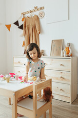 Little girl playing children tableware