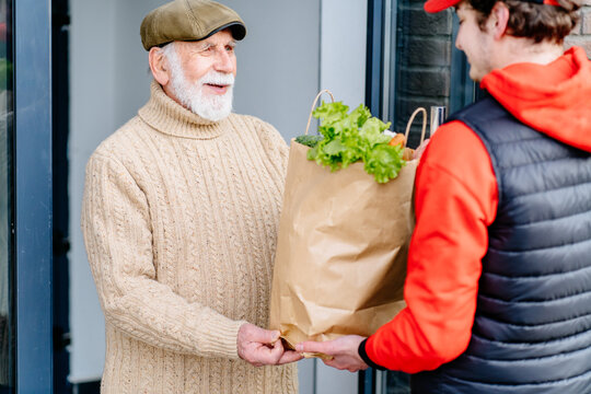 Old man meeting food delivery man. Seniors with gray beard and mustache