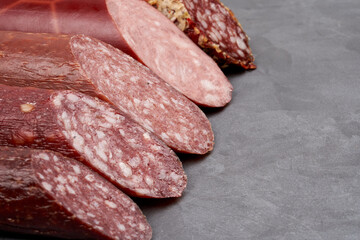 A set of smoked sausages with a cut on them. Gray background with copy space. Close-up.