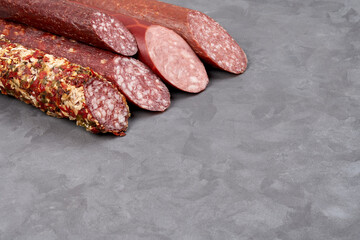 A set of smoked sausages with a cut on them. Gray background with copy space.