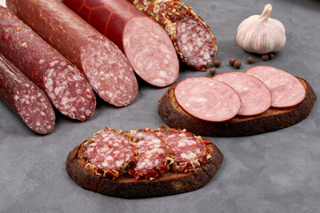 A set of smoked sausages and sandwiches with black bread made from it. Close-up still life.