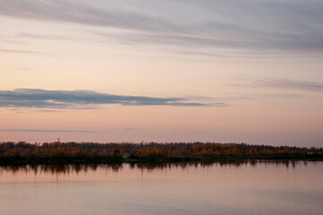 Obraz premium Sundown and sunrises. Blue sky with tints of purple and much clouds. Silhouettes of trees and grass are reflectioning in the river water. Background of heaven. Beautiful evening