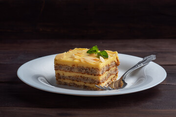 Banana sponge cake with nuts and mint. Delicious sweet dessert for tea, Dark wooden background.