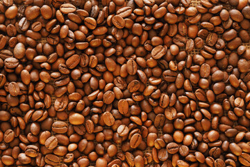 Roasted coffee beans on burlap as a background and texture.