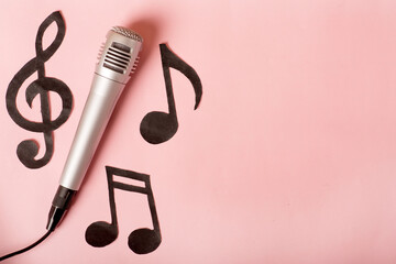 musical notes and microphone on a pink background.