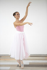 Naklejka premium Beautiful professional ballerina in pink dress dance in ballet studio