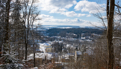 View of center of Czech town Marianske Lazne (Marienbad) from view point in spa forest - winter walk