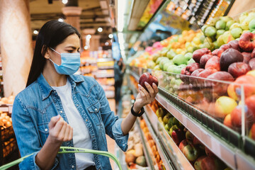 Young woman wearing face mask to stop virus spread choosing food