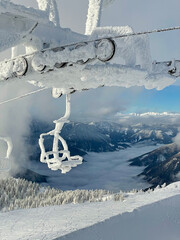 VERTICAL: Scenic view of the distant fog covered valley and a frozen chairlift.